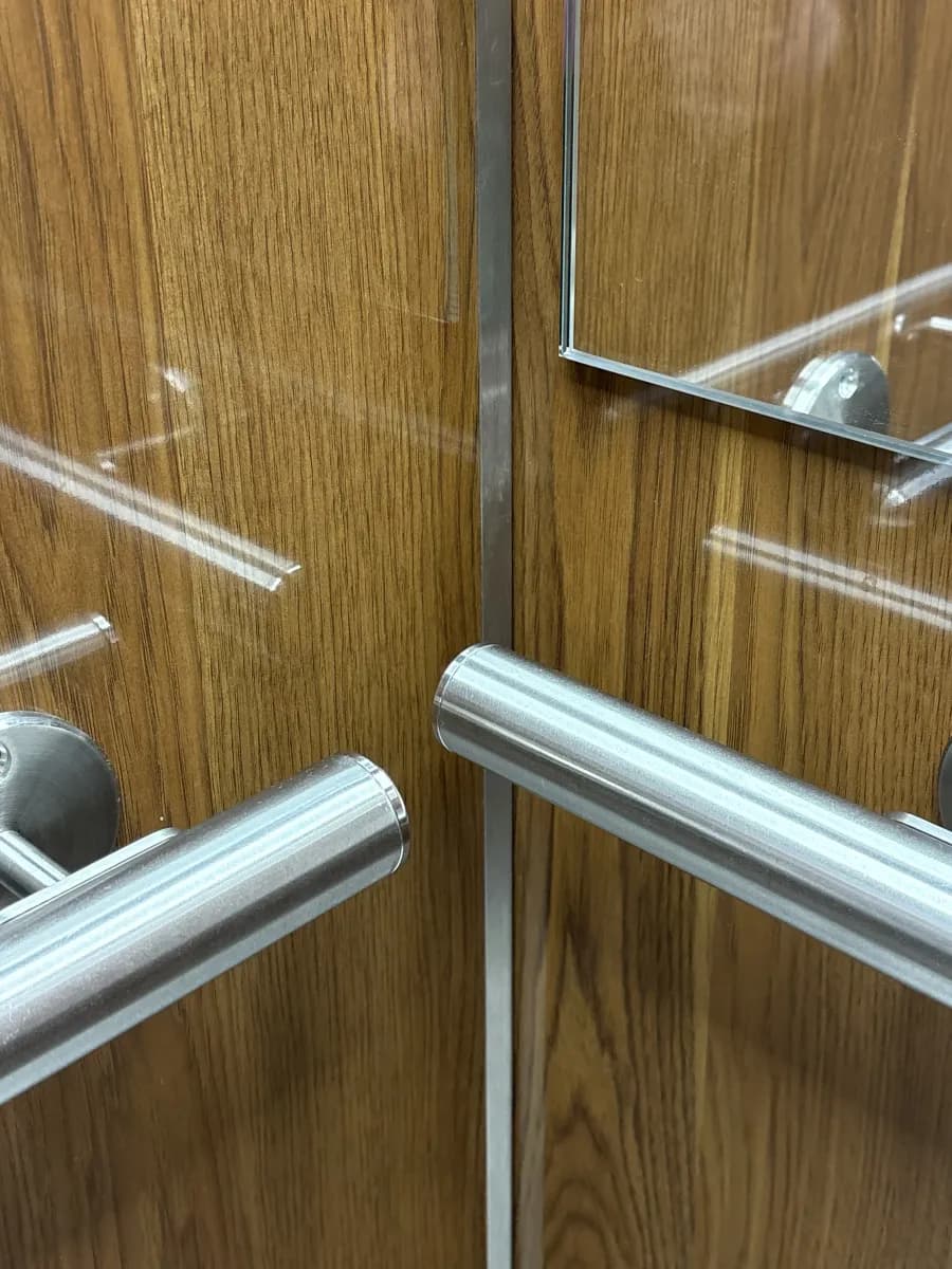 Détail des mains courantes inox et de l'habillage bois d'une cabine Kréasteel