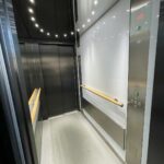 habillage cabine ascenseur inox, bois et pierre reconstituée